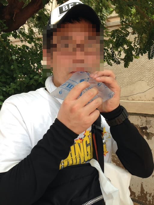 袋入り水を飲む